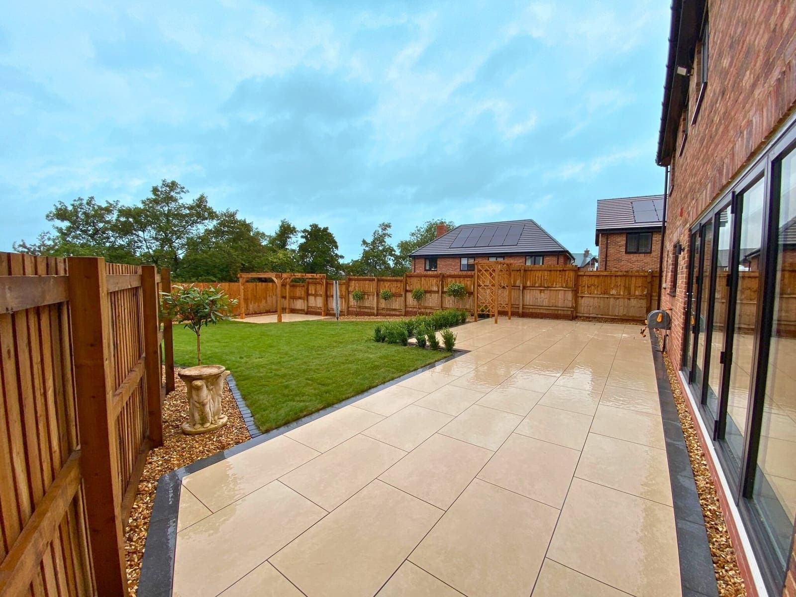 Beautiful premium landscaped garden with elegant porcelain paving, lawn and wooden structures
